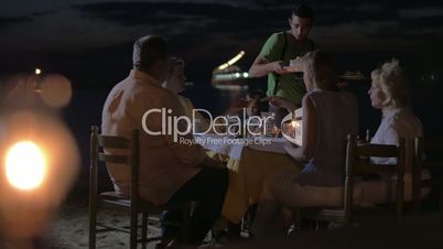 Waiter serving dinner for family in outdoor cafe