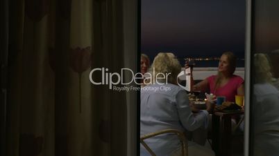 People dining and drinking wine on balcony