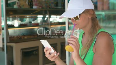 Woman using phone in street on summer day