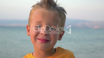 Little blond child on sea background