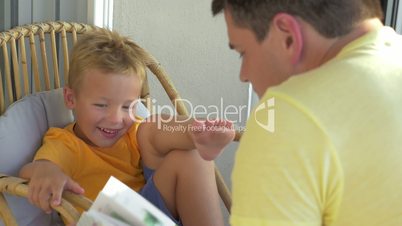 Smiling Boy Listening His Father Reading a Book