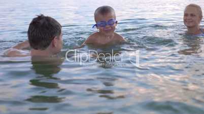 Boy Swimming in the Sea with Parents