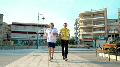 Father and Son in Headphones Jogging in Resort City