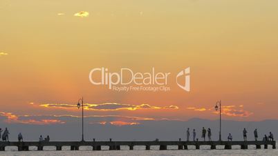 Cinemagraph - People enjoying seascape from the pier at sunset