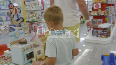 Child is attracted with toy cooker in supermarket