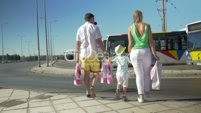 Family with shopping bags crossing the road