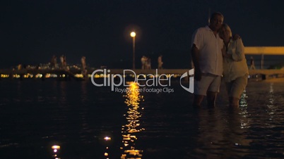 Senior couple and candles in night sea