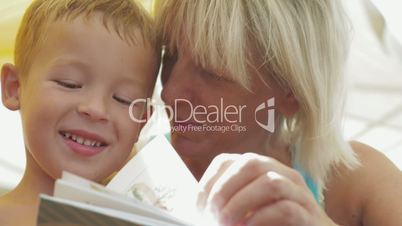 Grandmother reading a book to grandson