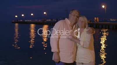 Senior couple in love by the sea at night