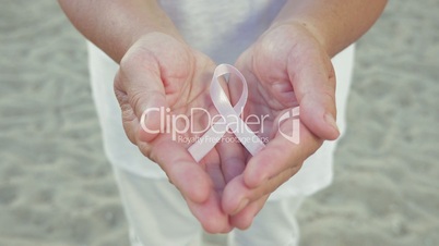 Breast cancer awareness ribbon in womans hands