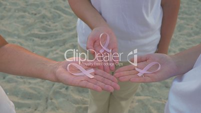 Three women with pink awareness ribbons