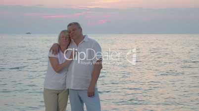 Senior couple by sea looking to the camera