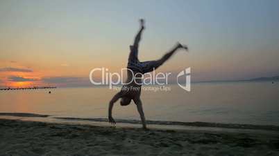 Man showing acrobatics at seaside during sunset
