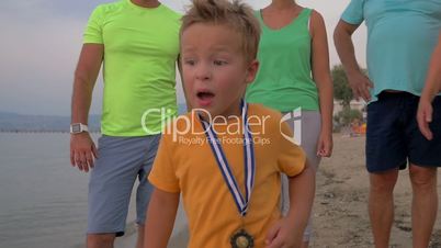 Happy little winner running with trophy