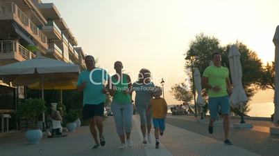 Happy family finishing evening run on resort