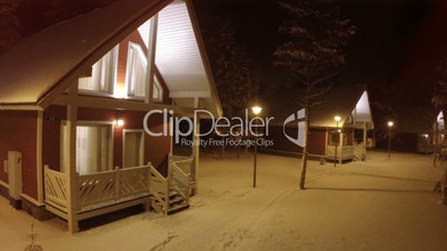 Flying over small wooden house in winter evening