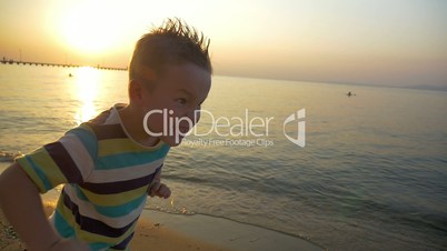 Child making angry face on the beach at sunset