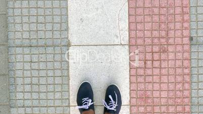 Man in sneakers walking on street