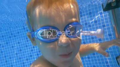 Child wearing goggles diving in the pool