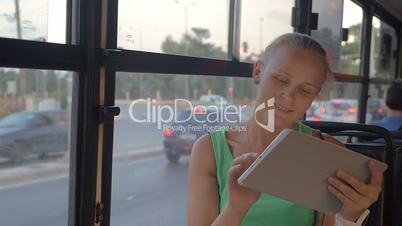 Young woman with touch pad traveling by bus
