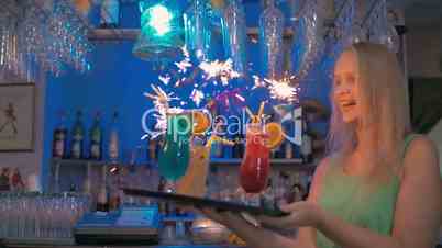 Waitress carrying cocktails with sparklers