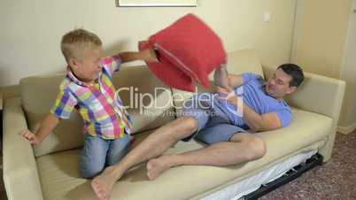 Dad and son fighting with cushions