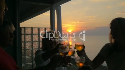 People toasting on the balcony at sunset