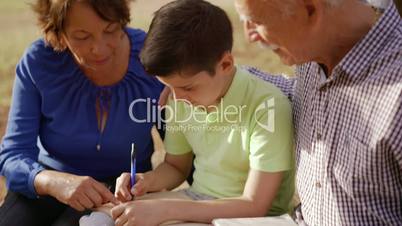 1-Grandpa And Grandma Helping Boy With Homework