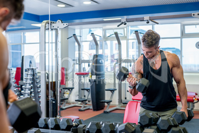 Man exercising with dumbbells in front of mirror