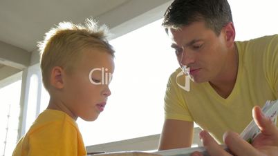 Father and child spending leisure with book