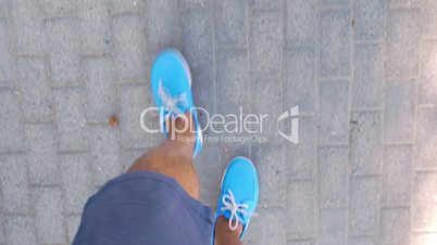 Man walking down the street in blue moccasins