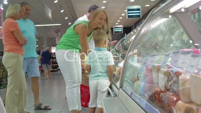 Family in front of Display Refrigerator in Supermarket