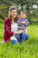 beautiful pregnant woman outdoor with her little boy