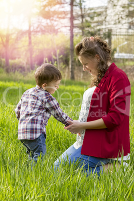 beautiful pregnant woman outdoor with her little boy