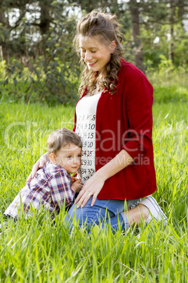 beautiful pregnant woman outdoor with her little boy