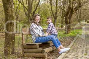 beautiful pregnant woman outdoor with her little boy