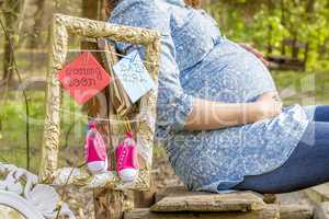 Pregnant woman outdoor in the park on bench