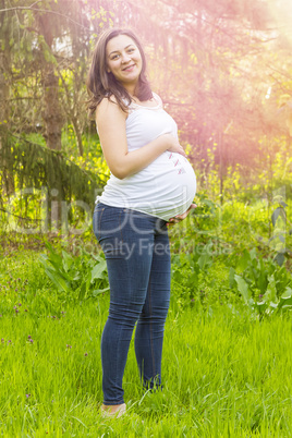 Pregnant woman outdoors in warm summer day