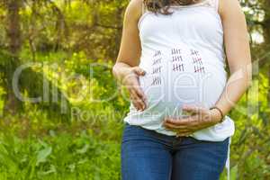Pregnant young woman outdoors close up.