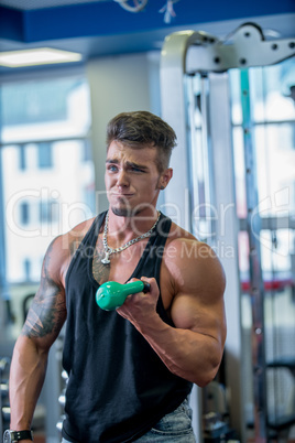 Guy made funny face while posing with dumbbell