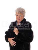 Senior woman in a black fur coat.