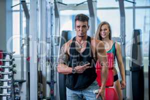 Shot of fitness instructor and girl smiling in gym