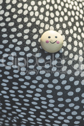 Smile icon on textile surface with points.
