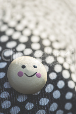 Smile icon on textile surface with points.