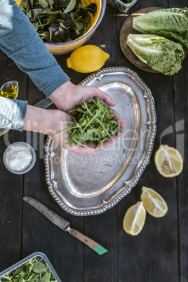 Preparing salad of arugula.