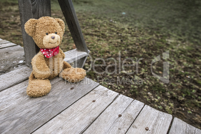 Teddy bear sitting on a pier