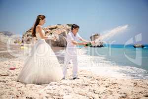 bride and groom open champagne on the beach Mediterranean Sea
