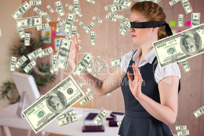 Composite image of redhead businesswoman in a blindfold