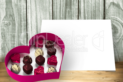 Composite image of heart shaped box of candy