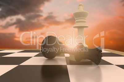 Composite image of white king standing over fallen black queen